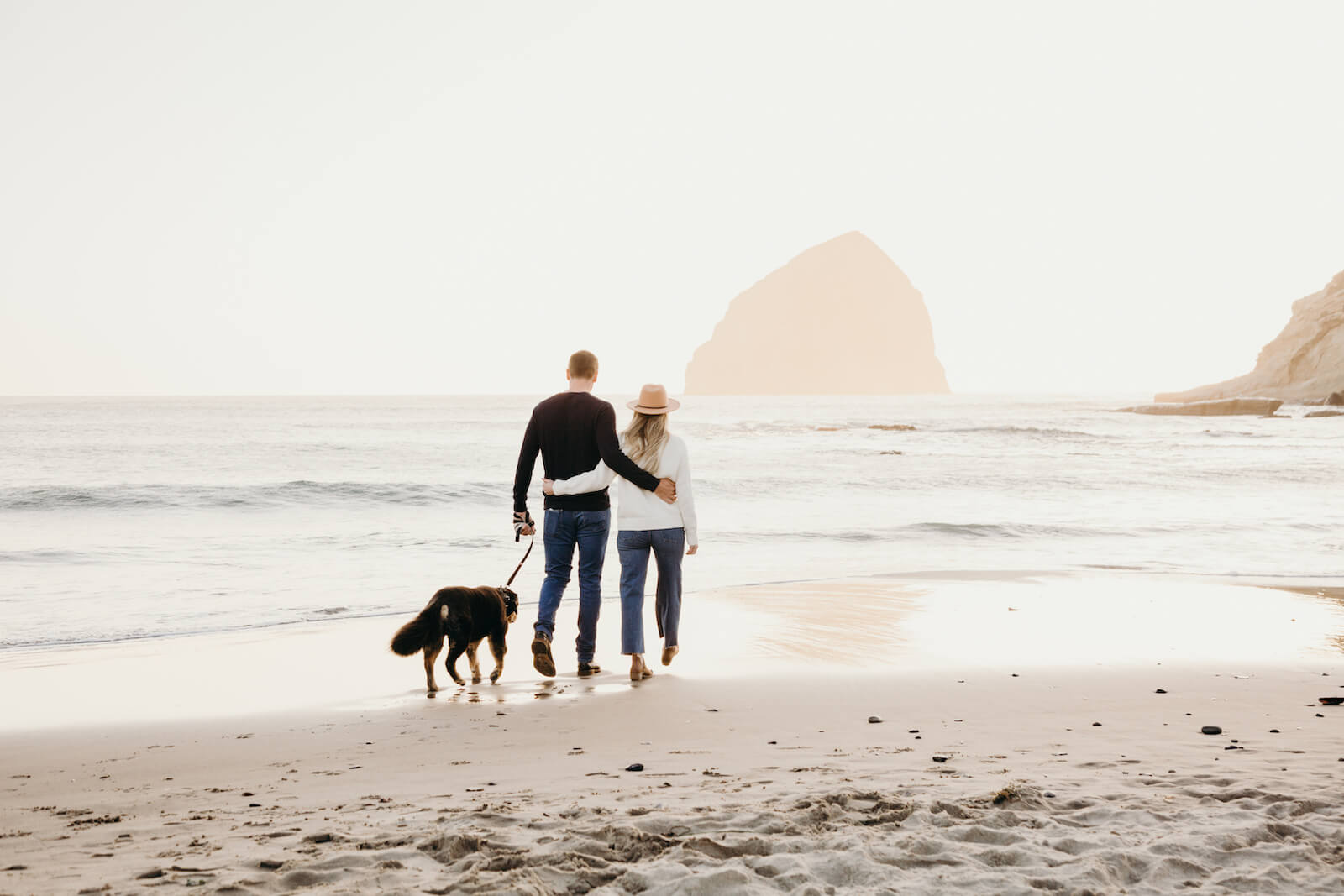 A couple and their dog admire the view at Canon Beach, Oregon