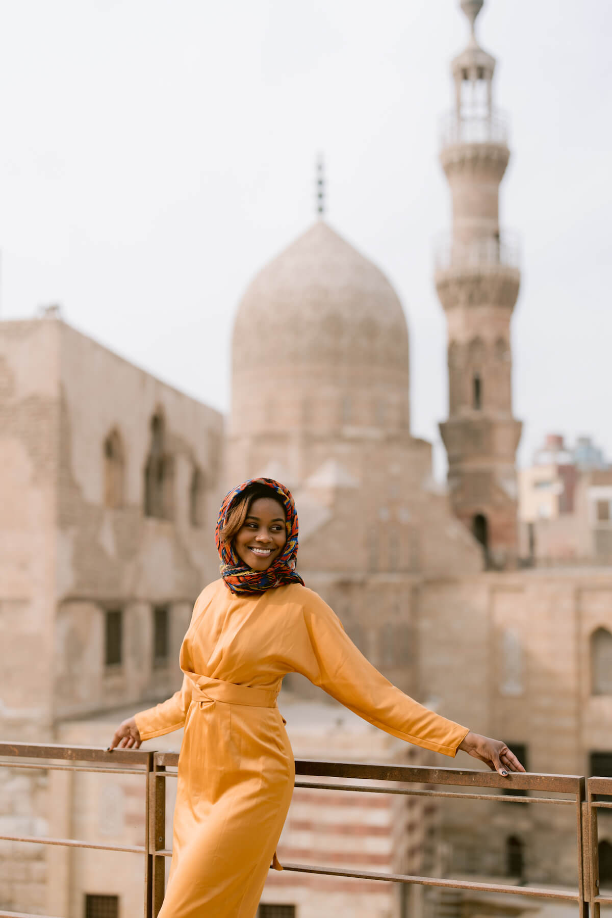 Headshot of a smiling woman on a bridge in front of a mosque